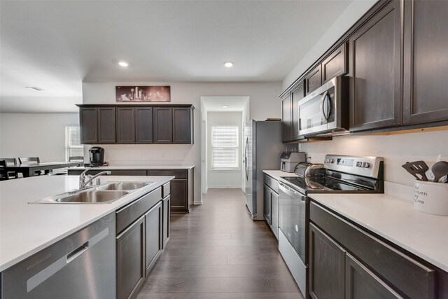 kitchen featuring dark brown cabinetry, sink, dark hardwood / wood-style floors, and appliances with stainless steel finishes