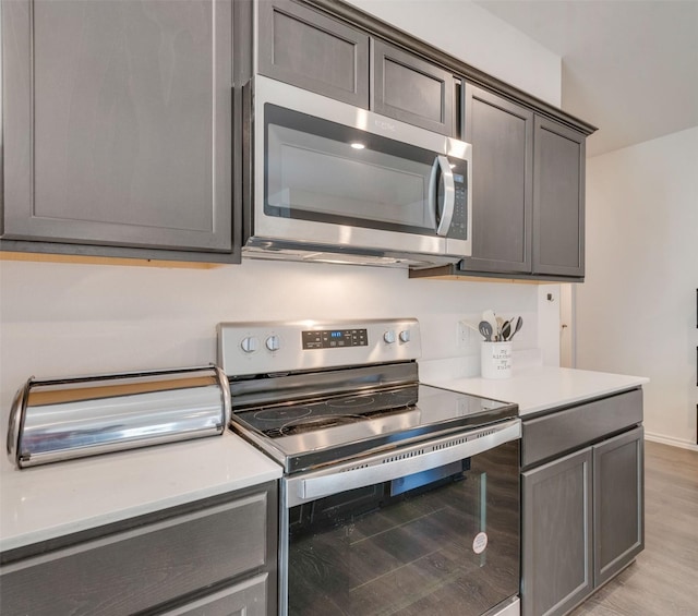 kitchen featuring appliances with stainless steel finishes and light hardwood / wood-style flooring