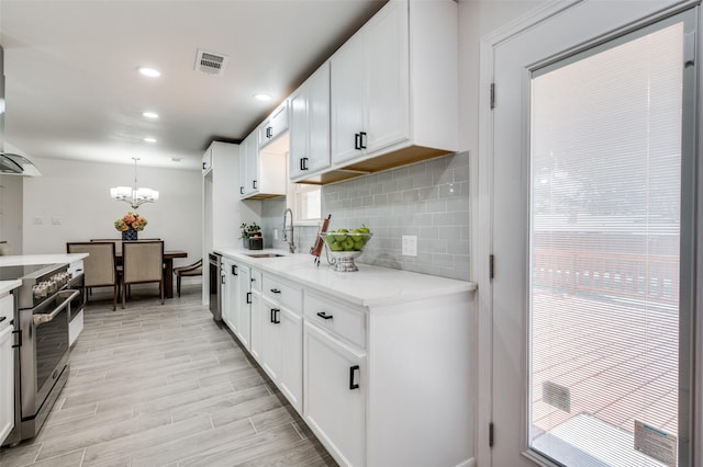 kitchen featuring white cabinets, pendant lighting, electric stove, and sink