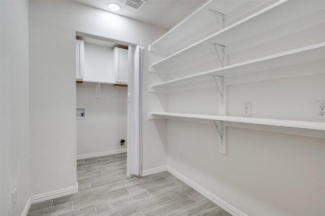 washroom with hookup for a washing machine and light wood-type flooring