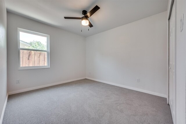 spare room with ceiling fan and light colored carpet