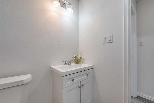 bathroom featuring hardwood / wood-style flooring, vanity, and toilet