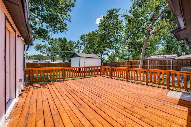 wooden deck featuring a shed and central air condition unit