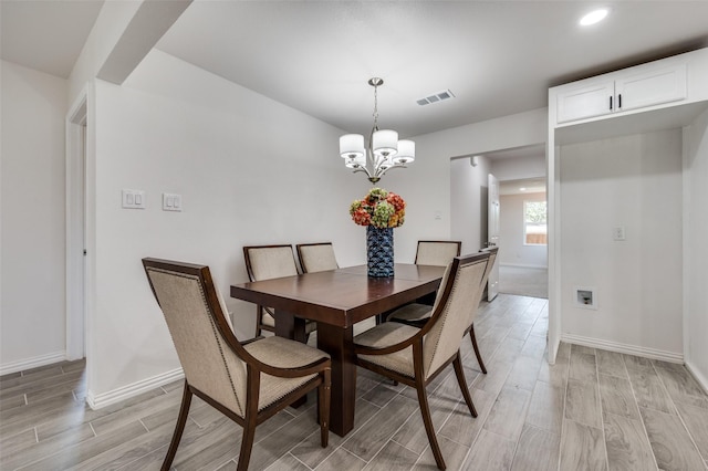 dining area featuring a notable chandelier and light hardwood / wood-style floors