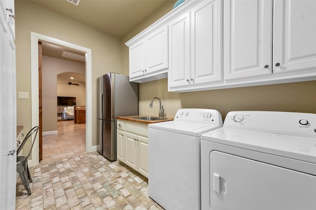 laundry area with cabinets, sink, ceiling fan, and washer and dryer