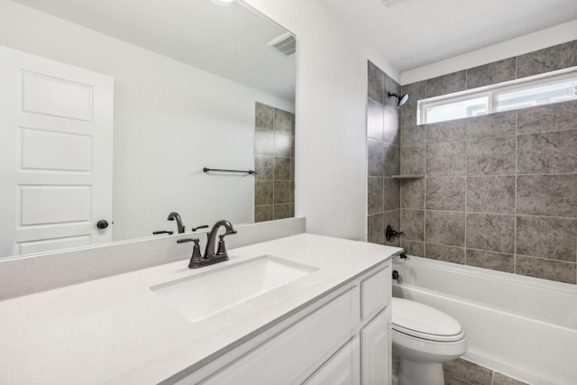 full bathroom featuring tiled shower / bath combo, vanity, and toilet