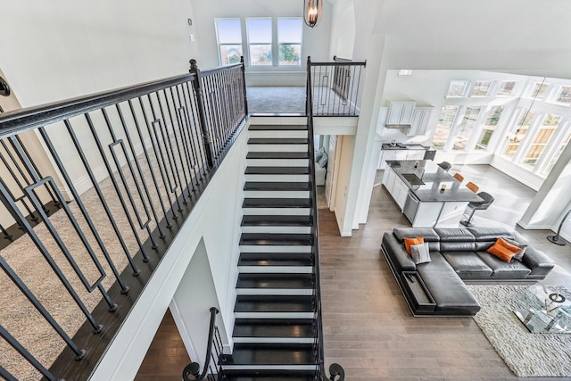 stairway featuring hardwood / wood-style flooring and a high ceiling