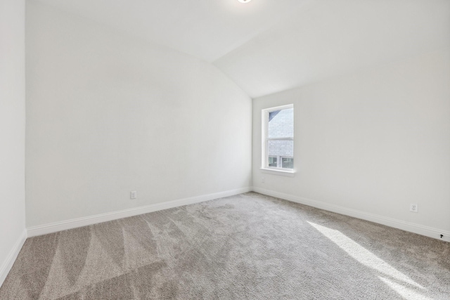 unfurnished room featuring lofted ceiling and carpet floors