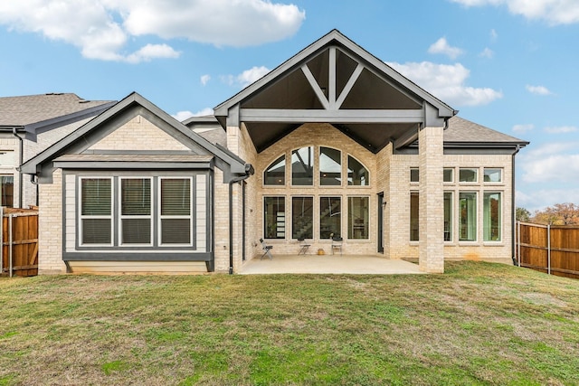 rear view of house featuring a lawn and a patio