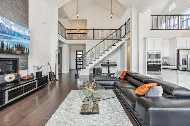 living room featuring dark hardwood / wood-style floors, high vaulted ceiling, and a wealth of natural light