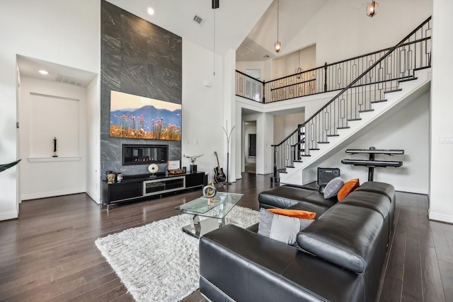 living room with dark wood-type flooring and a towering ceiling