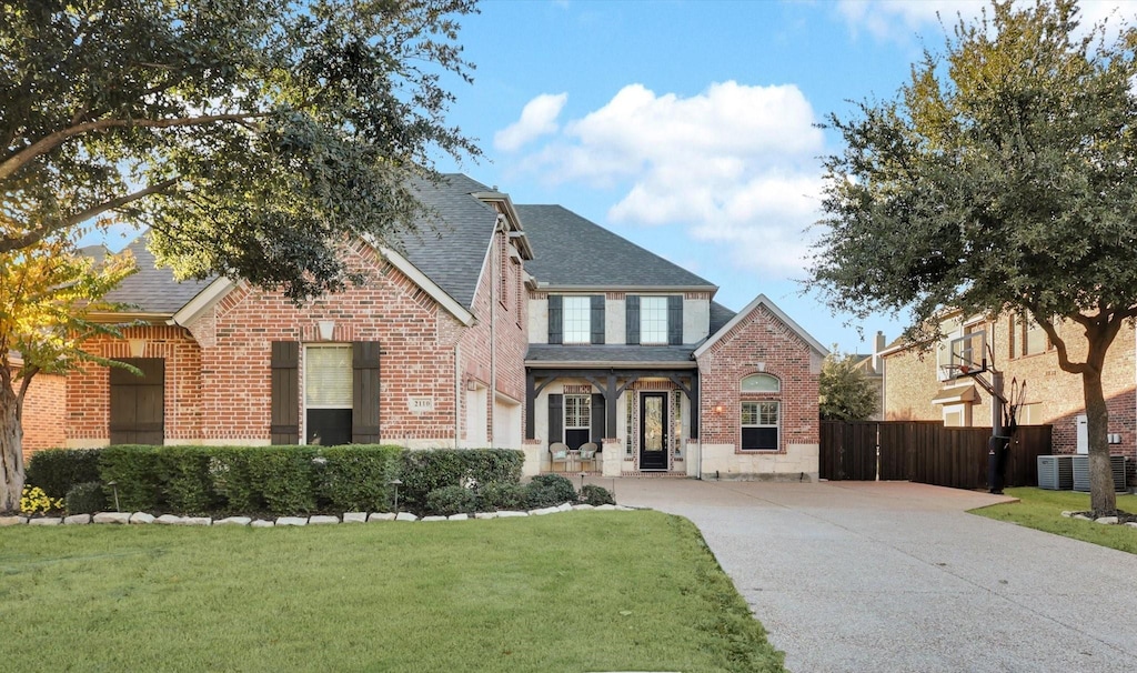 view of front of home with central AC and a front yard