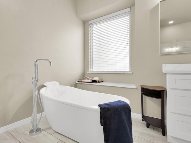 bathroom featuring vanity and a tub