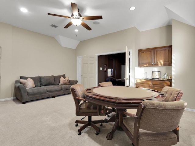 carpeted dining space featuring vaulted ceiling and ceiling fan