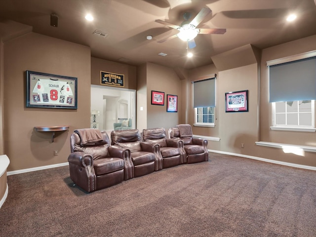 home theater room with ceiling fan and carpet