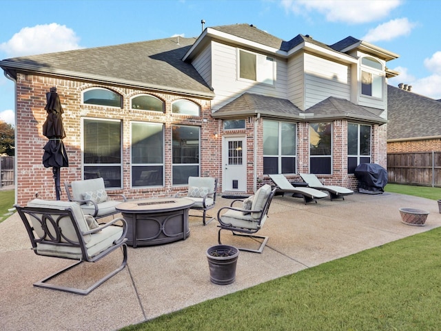 rear view of property with a patio and an outdoor living space with a fire pit