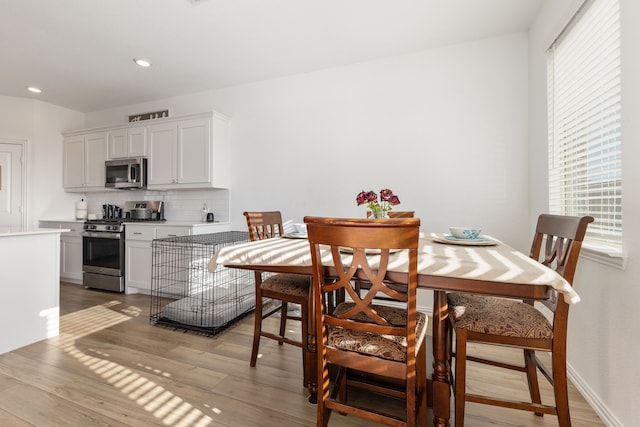 dining space featuring recessed lighting, a healthy amount of sunlight, light wood-style floors, and baseboards