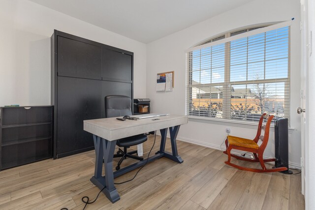 office area featuring light wood finished floors and baseboards