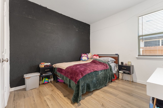 bedroom featuring baseboards and wood finished floors