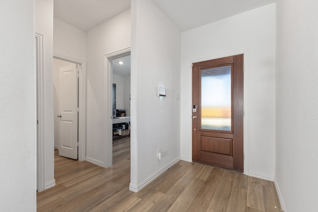 foyer with baseboards and light wood finished floors