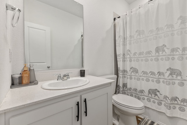 bathroom featuring a shower with curtain, toilet, and vanity