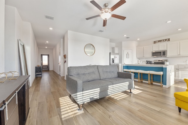 living area featuring recessed lighting, a ceiling fan, visible vents, and light wood finished floors