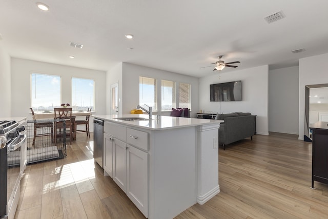 kitchen featuring visible vents, a sink, stainless steel appliances, light wood-style floors, and a healthy amount of sunlight