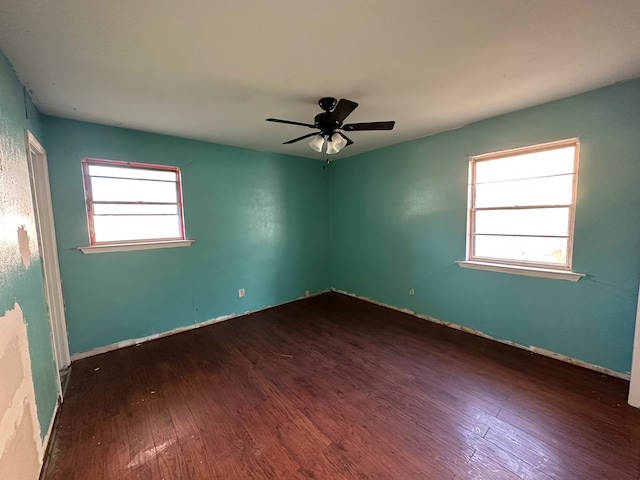 empty room featuring plenty of natural light, dark hardwood / wood-style floors, and ceiling fan