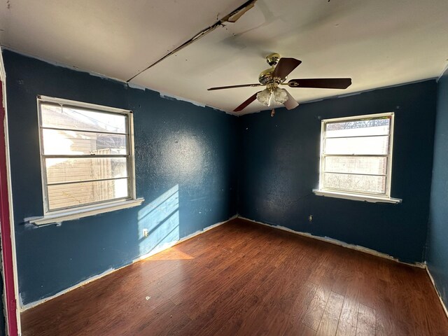 unfurnished room with dark hardwood / wood-style floors and ceiling fan