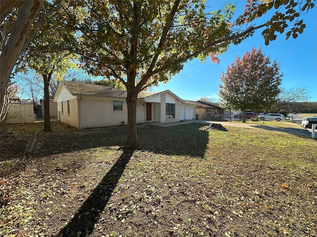 view of side of property featuring a garage and a yard