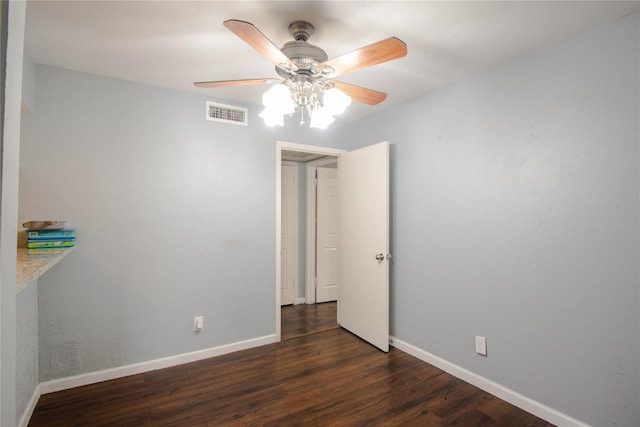 spare room featuring ceiling fan and dark wood-type flooring