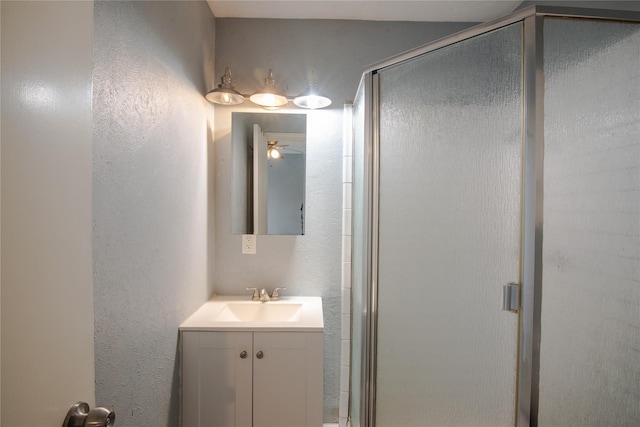 bathroom with ceiling fan, vanity, and a shower with shower door