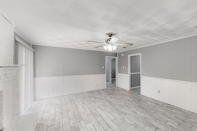 empty room with crown molding, light hardwood / wood-style floors, and ceiling fan