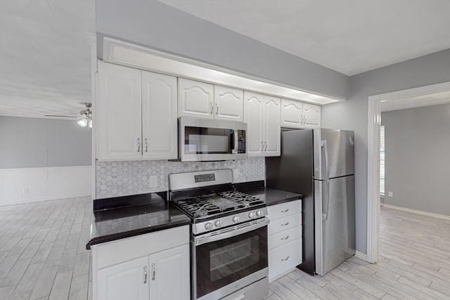 kitchen with white cabinetry, appliances with stainless steel finishes, ceiling fan, and decorative backsplash