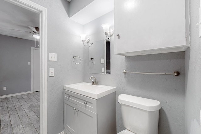 bathroom with vanity, toilet, and ceiling fan