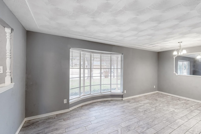 spare room featuring light hardwood / wood-style floors and a notable chandelier