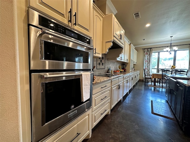 kitchen featuring crown molding, tasteful backsplash, a notable chandelier, light stone counters, and stainless steel double oven