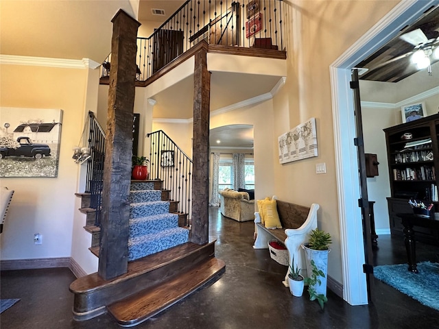 foyer featuring a high ceiling, ceiling fan, and crown molding