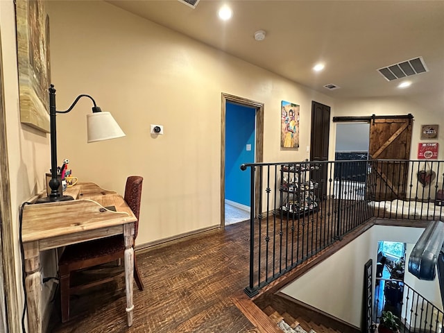 hallway featuring dark hardwood / wood-style flooring and a barn door