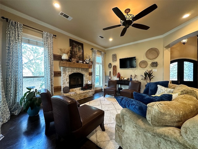 living room featuring ceiling fan, french doors, a stone fireplace, hardwood / wood-style floors, and ornamental molding