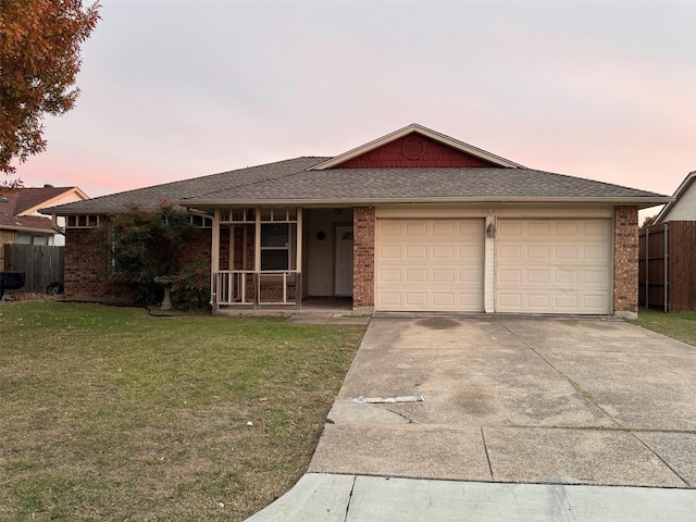 ranch-style house featuring a lawn and a garage