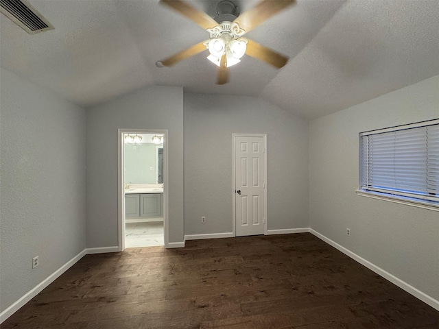 additional living space with a textured ceiling, dark hardwood / wood-style floors, vaulted ceiling, and ceiling fan