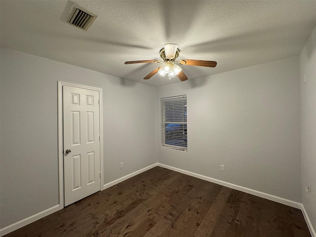 spare room with a textured ceiling, ceiling fan, and dark hardwood / wood-style floors