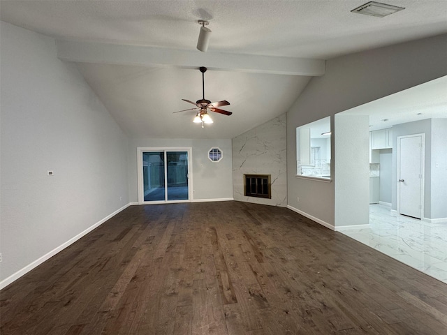 unfurnished living room with lofted ceiling with beams, hardwood / wood-style flooring, ceiling fan, a premium fireplace, and a textured ceiling