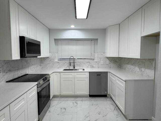 kitchen with appliances with stainless steel finishes, tasteful backsplash, white cabinetry, and sink