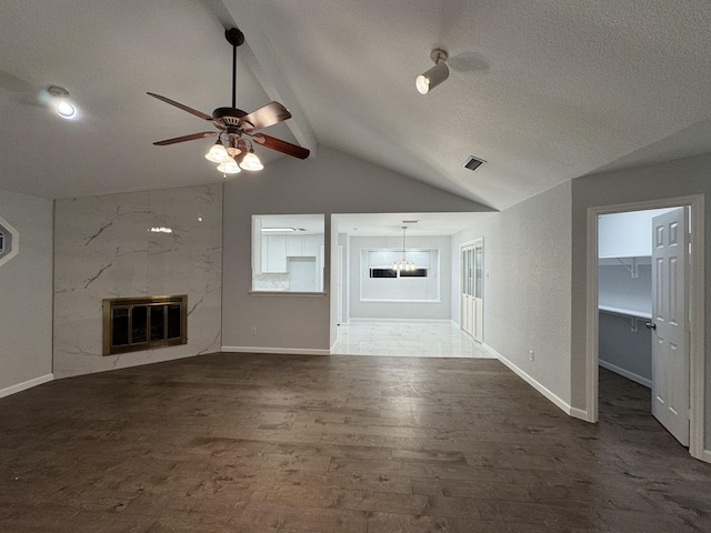 unfurnished living room with lofted ceiling with beams, dark hardwood / wood-style floors, ceiling fan, a premium fireplace, and heating unit