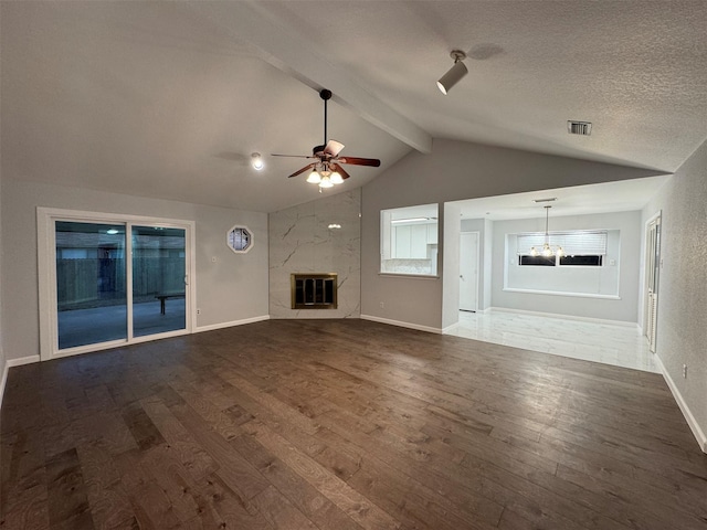 unfurnished living room featuring lofted ceiling with beams, dark hardwood / wood-style floors, ceiling fan, a premium fireplace, and a textured ceiling