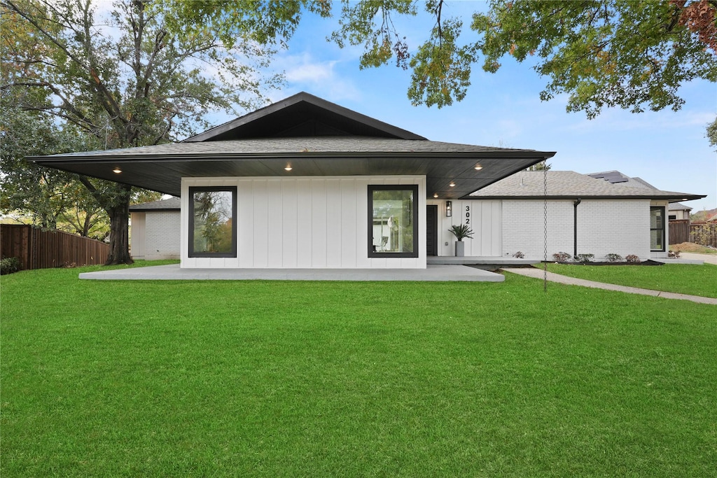 back of property with a yard and a patio area