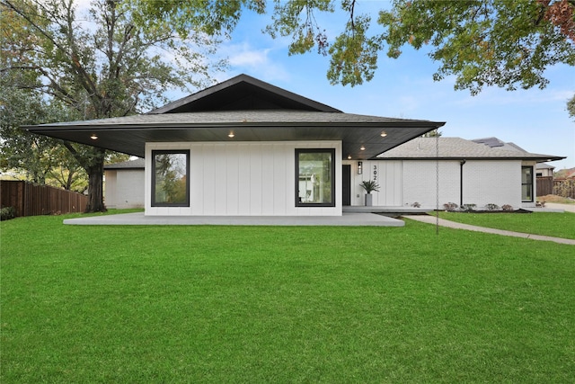 back of property with a yard and a patio area