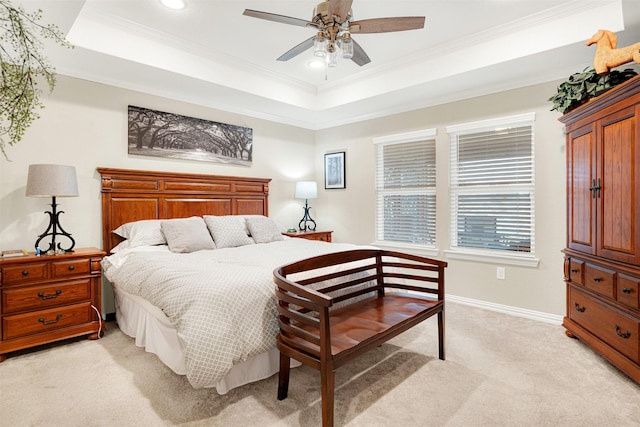 carpeted bedroom featuring a tray ceiling, ceiling fan, and crown molding